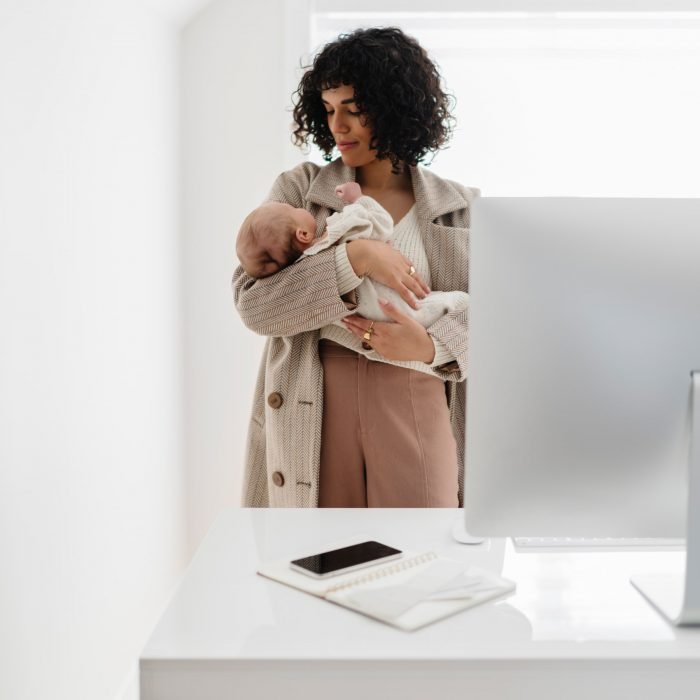 A mother holding a baby in an office