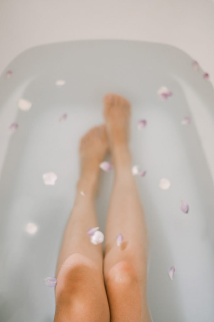 Legs in bath water and rose petals