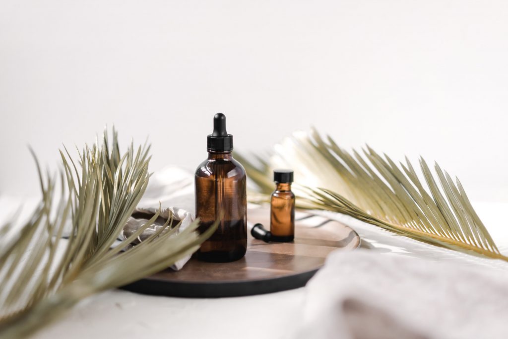 Essential oils for brain fog next to two leaves of a plant