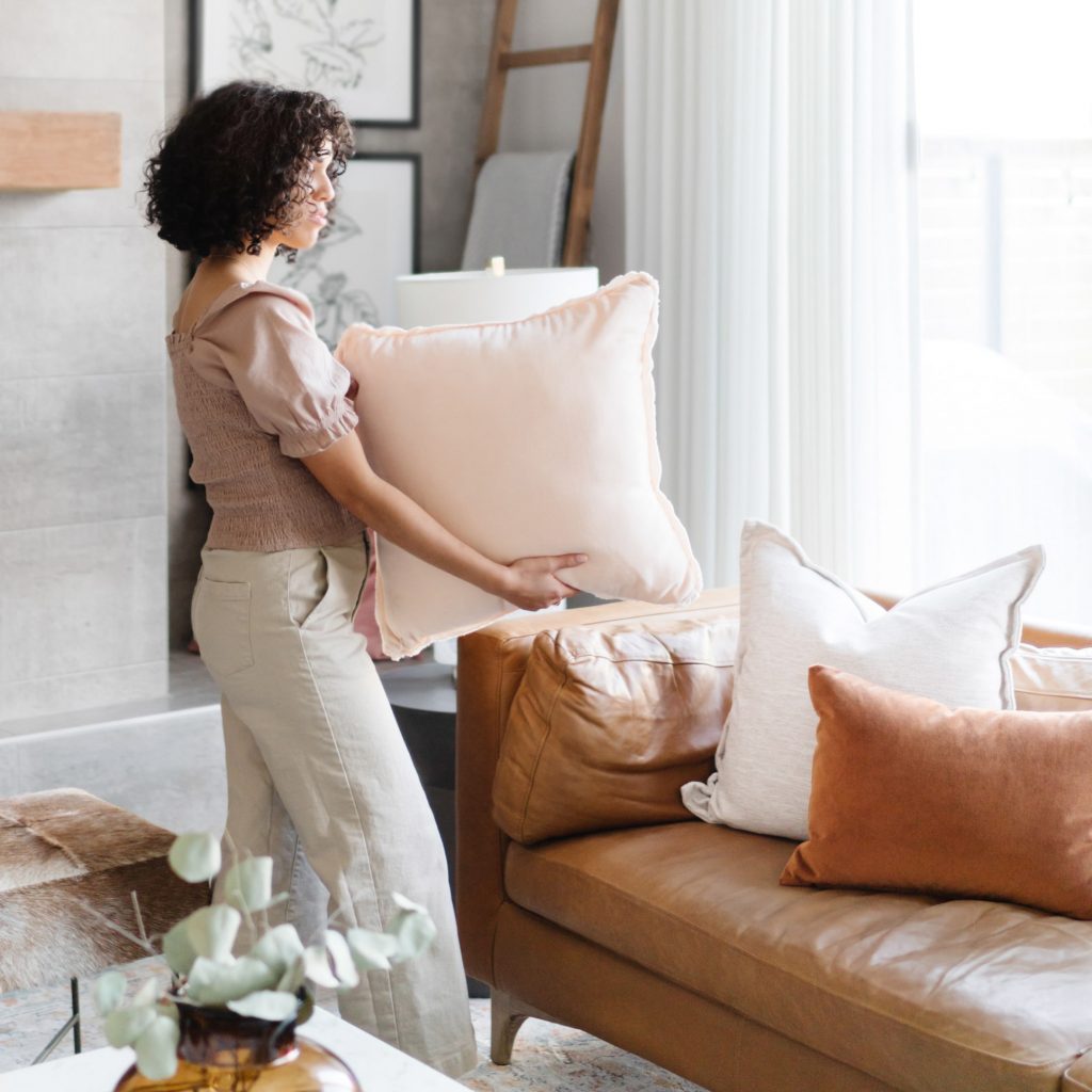 A woman plumping some cushions