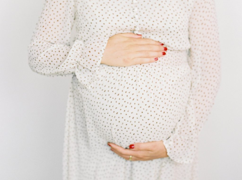 A pregnant woman holding her bump. 