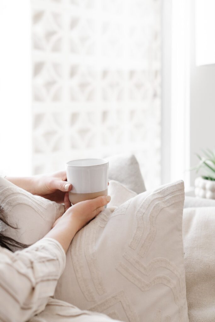 A woman drinking a hot drink in bed