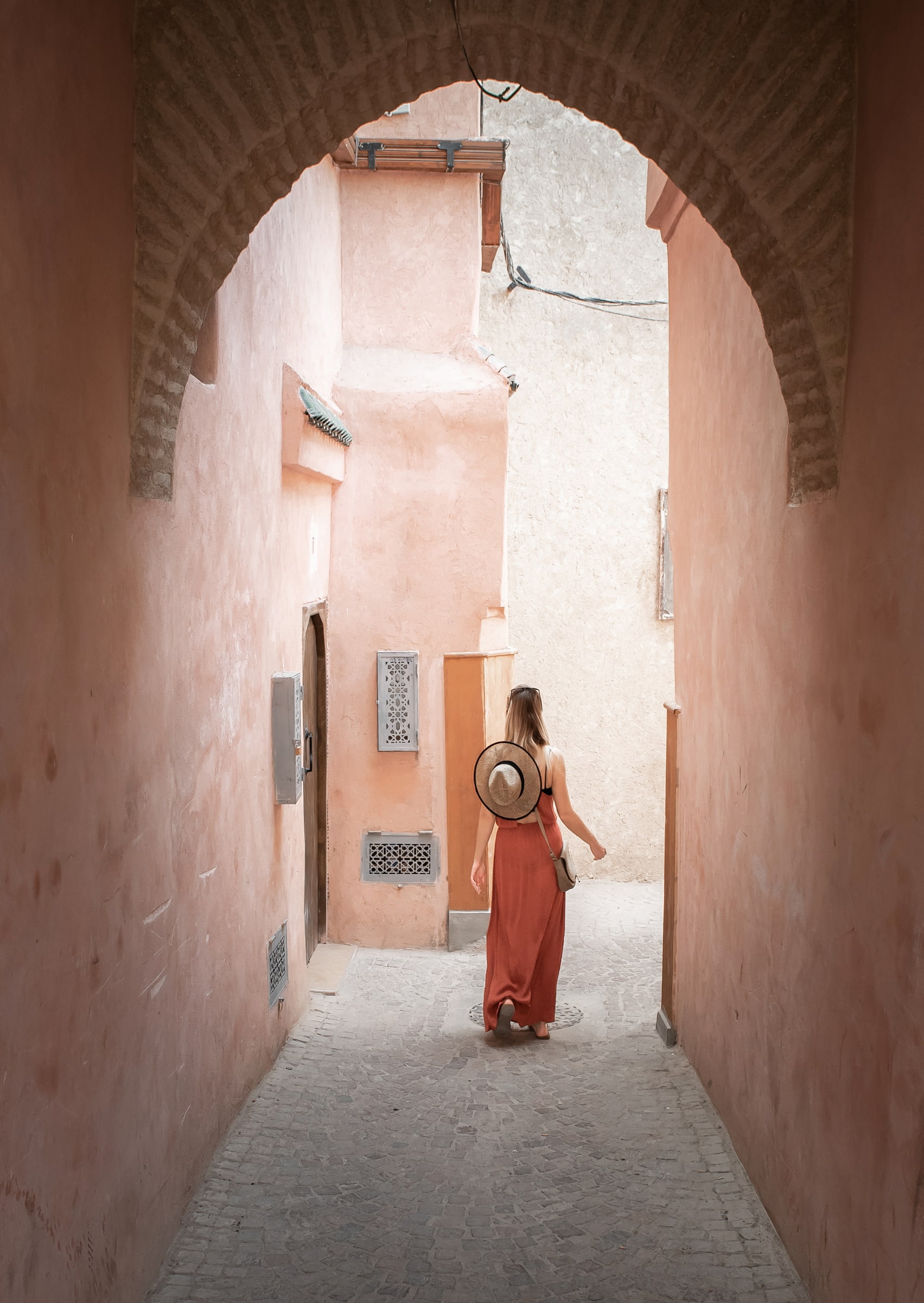 A woman walking through an archway in an Arabic style town