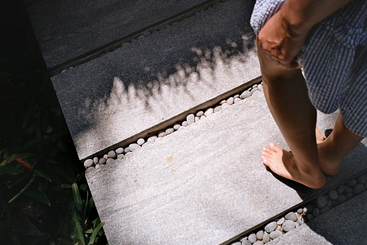 poems about strength - a woman walking on a boardwalk, shot of her feet only. 