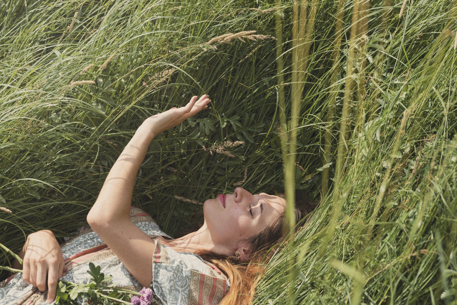 poetry journaling - a woman lying in long grass.